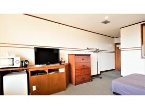a room with a flat screen tv and a bedroom at Ｐｕｒａｒｉ - Vacation STAY 81709v in Takahara