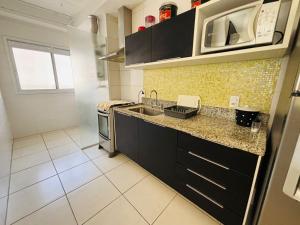 Η κουζίνα ή μικρή κουζίνα στο Guarujá condomínio Villa Di fiori AP jasmim