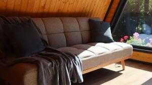 a couch with two pillows on it in front of a window at Hanul Haiducilor in Şendreni