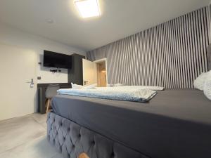 a bedroom with a large bed with a tv on the wall at All In in Oberhausen