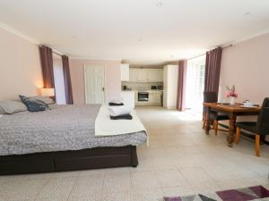a bedroom with a bed and a desk and a table at Garden apartment in Llandysul