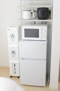 a white kitchen with a microwave and two boxes at Rana Enoshima - Vacation STAY 84717v in Fujisawa