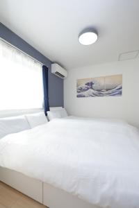 a white bed in a room with a window at Rana Enoshima - Vacation STAY 94777v in Fujisawa