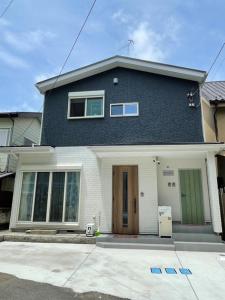 a large blue house with a door on a street at Rana Enoshima - Vacation STAY 94777v in Fujisawa