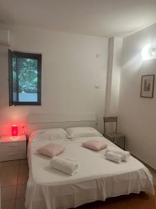 a bedroom with a white bed with two pillows on it at I Tramonti del Salento in Gallipoli