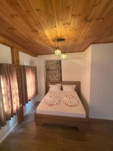 a bedroom with a bed with a wooden ceiling at Hotel Borklad in Berat