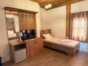 a bedroom with a bed and a tv in a room at Hotel Borklad in Berat