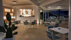 a restaurant with tables and chairs and a plant at Sunset Beach Club Tropea in Tropea