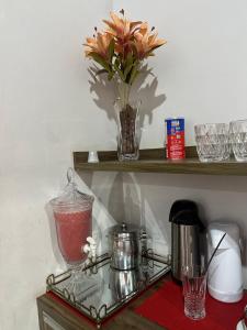 a glass shelf with a blender and a vase of flowers at Hotel Manarela in Imperatriz +26 photos