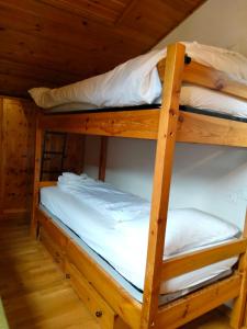 two bunk beds in a cabin with white sheets at VAL DI FASSA CENTRAL HOUSE - Rooms with free parking in Canazei