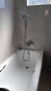 een badkuip met douche in een badkamer bij Thukhana House in Maun