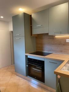 a kitchen with white cabinets and a black oven at Il Nido di Poppi in Poppi