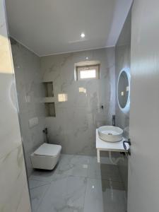 a white bathroom with a toilet and a sink at Break Room Dea in Draçi