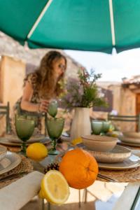 a woman sitting at a table under an umbrella at Casa Rural El Viejo Almacén, a 20 minutos de Segovia in Losana de Pirón +82 photos