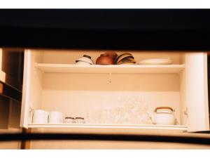 a shelf with cups and other items on it at Tenjin Tabine - Vacation STAY 24229v in Kanazawa