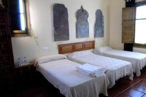 a room with two beds and two windows at La Quinta de Melque in San Martín de Montalbán +4 photos