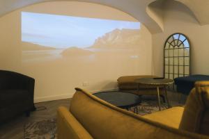 a living room with a large screen in a room at Elégante maison amiénoise - jacuzzi, home-cinéma, proche gare - La Maison Des Petits Sablon in Amiens