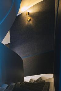 a room with a bed and a light on the wall at Elégante maison amiénoise - jacuzzi, home-cinéma, proche gare - La Maison Des Petits Sablon in Amiens