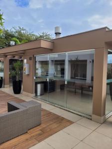 a house with glass walls and a patio at Ap Royal Mirage in Florianópolis