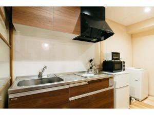 a small kitchen with a sink and a microwave at Tenjin Tabine - Vacation STAY 24241v in Kanazawa