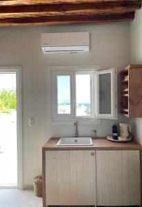 a kitchen with a sink and two windows at Kisari Kimolos Chorio Double Room in Kimolos +40 photos