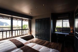 una camera con letto e un balcone con finestre di Itoshima810Villa&Resort - Vacation STAY 24393v a Itoshima