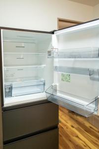 an empty refrigerator with its door open in a kitchen at Mine House Noritake Shinmachi - Vacation STAY 24243v in Nagoya