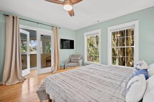 a bedroom with a large bed and two windows at Oystershell Cottage in Port Royal