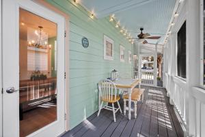 a porch with a table and a ceiling fan at Oystershell Cottage in Port Royal