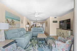 a living room with a blue couch and a tv at The Summit #9E - Oceanfront in Myrtle Beach