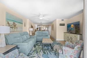 a living room with blue couches and a ceiling fan at The Summit #9E - Oceanfront in Myrtle Beach +44 photos