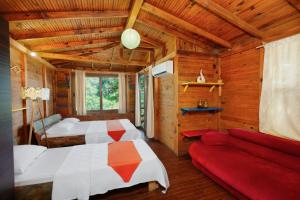 a bedroom with two beds and a red couch at Lilith Pan Bungalows in Fethiye