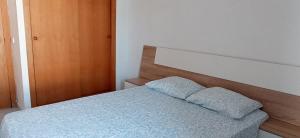 a bedroom with a bed with a wooden headboard at Tramuntana Beach in Calafell