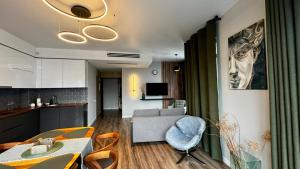 a living room with a couch and a table and chairs at Stylish apartments White Sails View in Batumi