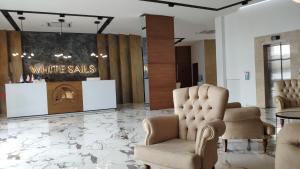 a waiting room with white chairs and a table at Stylish apartments White Sails View in Batumi +10 photos