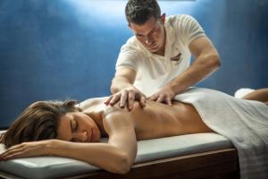 a man getting a woman on a bed at Hotel Delle Terme Di Venturina in Venturina Terme