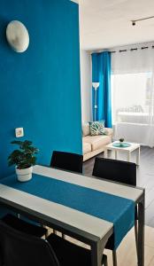 a living room with a table and a blue wall at Sunshine Beach Apartments in Adeje