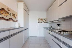 a large white kitchen with white cabinets and appliances at Luxury Vintage Rooftop Appartment in Antibes