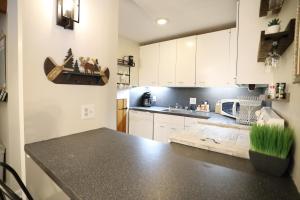a kitchen with white cabinets and a black counter top at Snowsbrook 5 WV in Waterville Valley