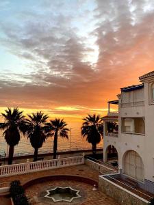 a building with palm trees in front of the ocean at Fuentes de Nerja in Nerja +35 photos
