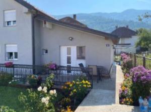 a white house with flowers in front of it at Emina in Plav