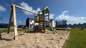 a playground with a slide in the sand at Sunbella Sarbinowo in Sarbinowo