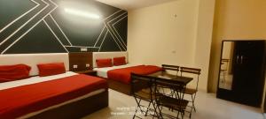a bedroom with two beds and a desk and a table at The Himalayan Inn Hotel in Narendranagar +21 photos
