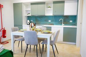 a kitchen with a white table and chairs at Terracina Seaside Apartments in Lido Di Fondi