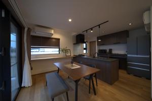 a kitchen with a wooden table and a dining room at LAGUNA OKINAWA Beachfront - Vacation STAY 30548v in Yaka