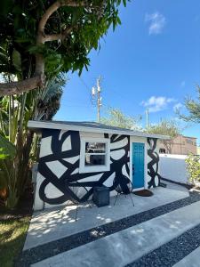 une petite maison avec un tableau sur le côté dans l'établissement 1BD 1BA-Black&White ArtBNB Cottage-Antique Row WPB, à West Palm Beach