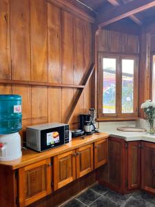 a kitchen with a microwave on a wooden counter at TONYs HOUSE MINDO in Mindo +19 photos