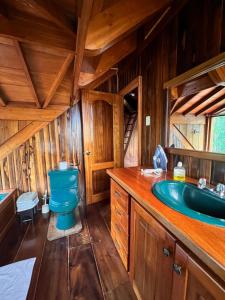 a bathroom with a blue toilet and a sink at TONYs HOUSE MINDO in Mindo