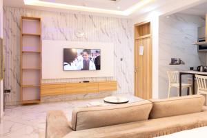 un salon avec un canapé et une télévision dans l'établissement Classy Studio Apartment, East Airport, à Accra