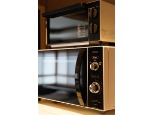 un forno a microonde appoggiato su uno scaffale accanto a un fornetto tostapane di Isizue Tabine - Vacation STAY 30862v a Kanazawa